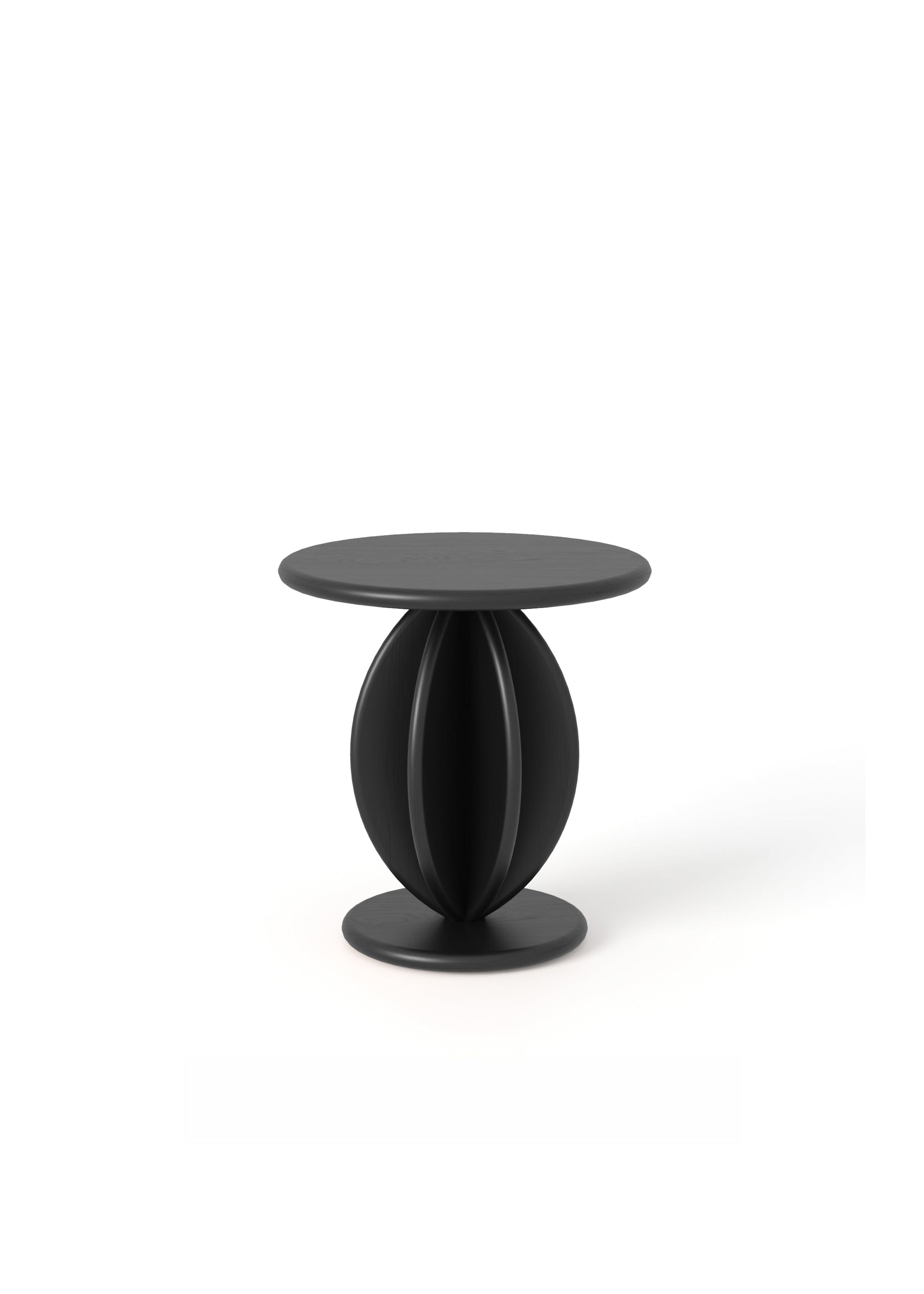 Dwa czarne stoliki o okrągłym blacie i rzeźbionej podstawie ustawione przy sofie