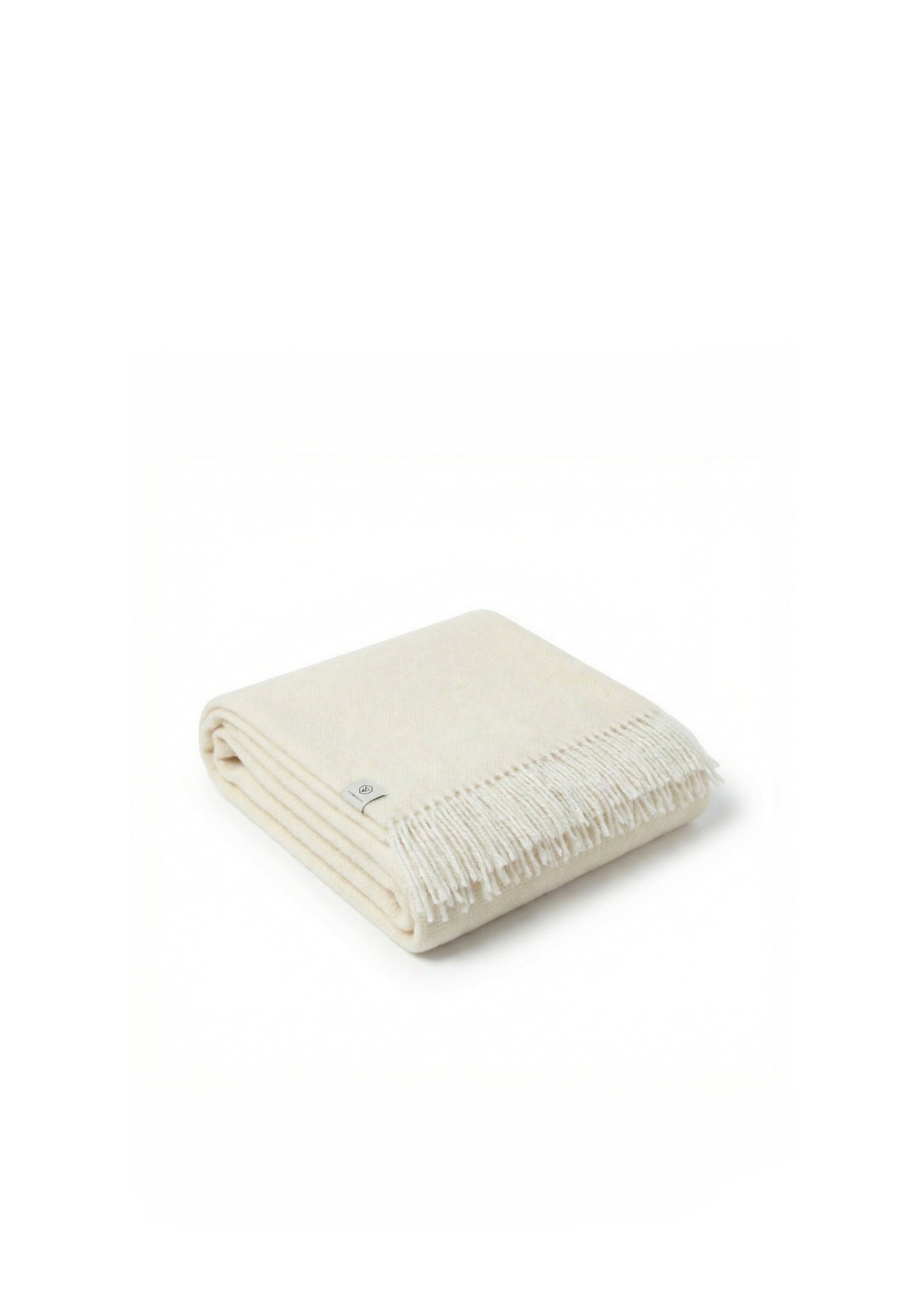 Couverture en laine crème avec franges, drapée sur une chaise en bois