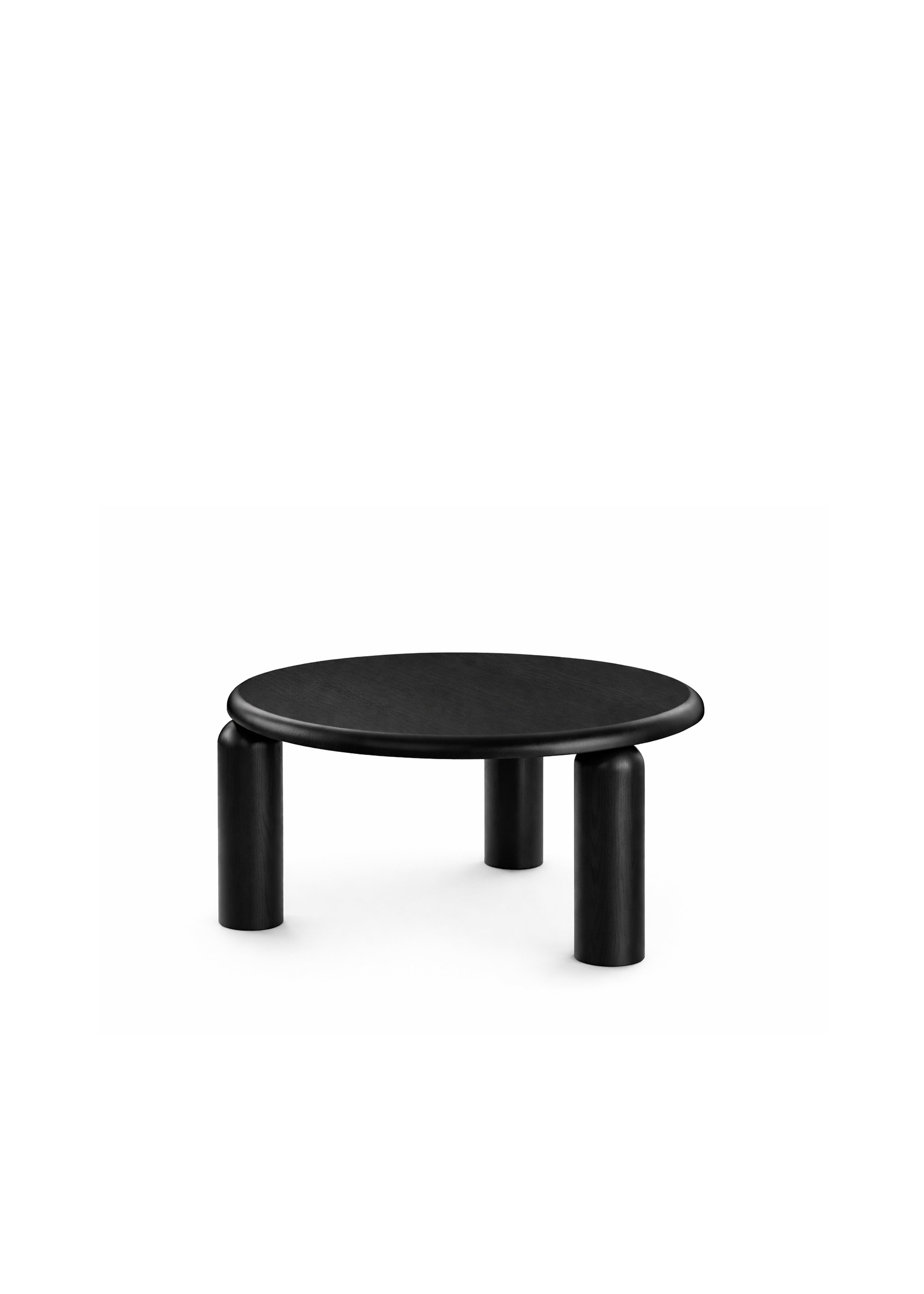 Okrągły czarny stolik kawowy i czerwony stolik boczny umieszczone obok zakrzywionej beżowej sofy w jasnym salonie.