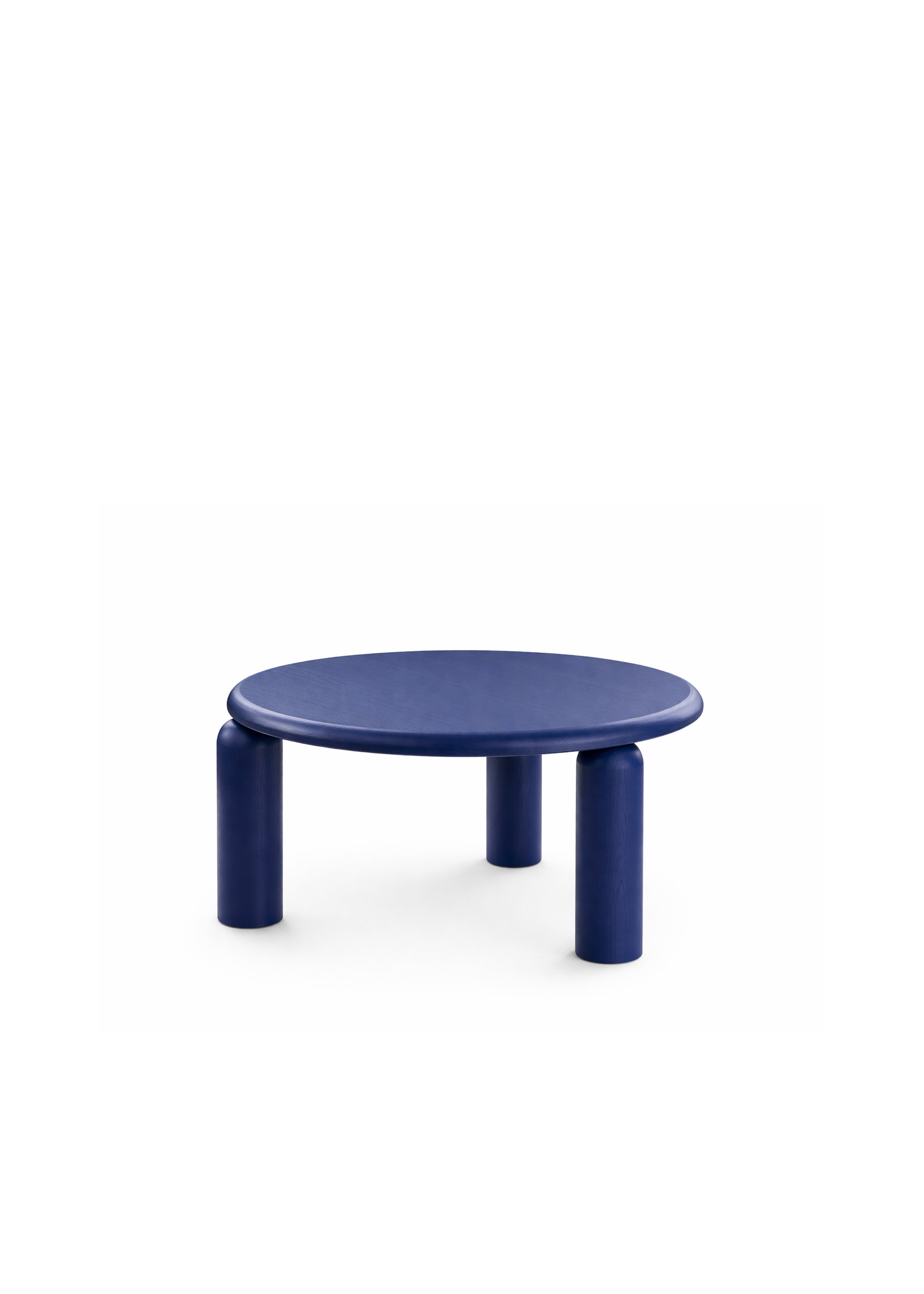 Okrągły niebieski stolik kawowy z trzema solidnymi nogami ustawiony przed teksturowaną sofą modułową.