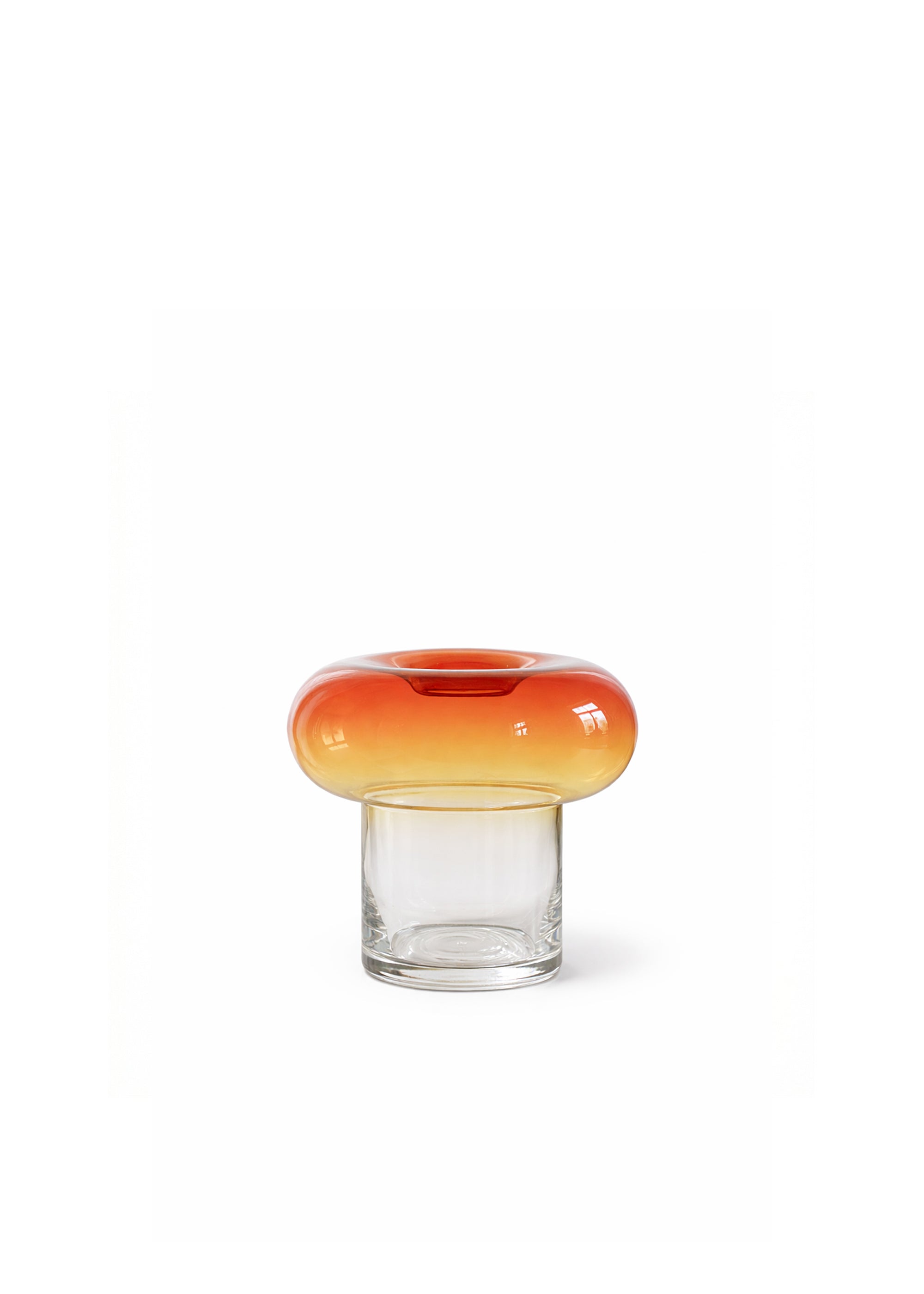 Szklany wazon z dwoma suchymi kwiatami przy jasnej zasłonie.