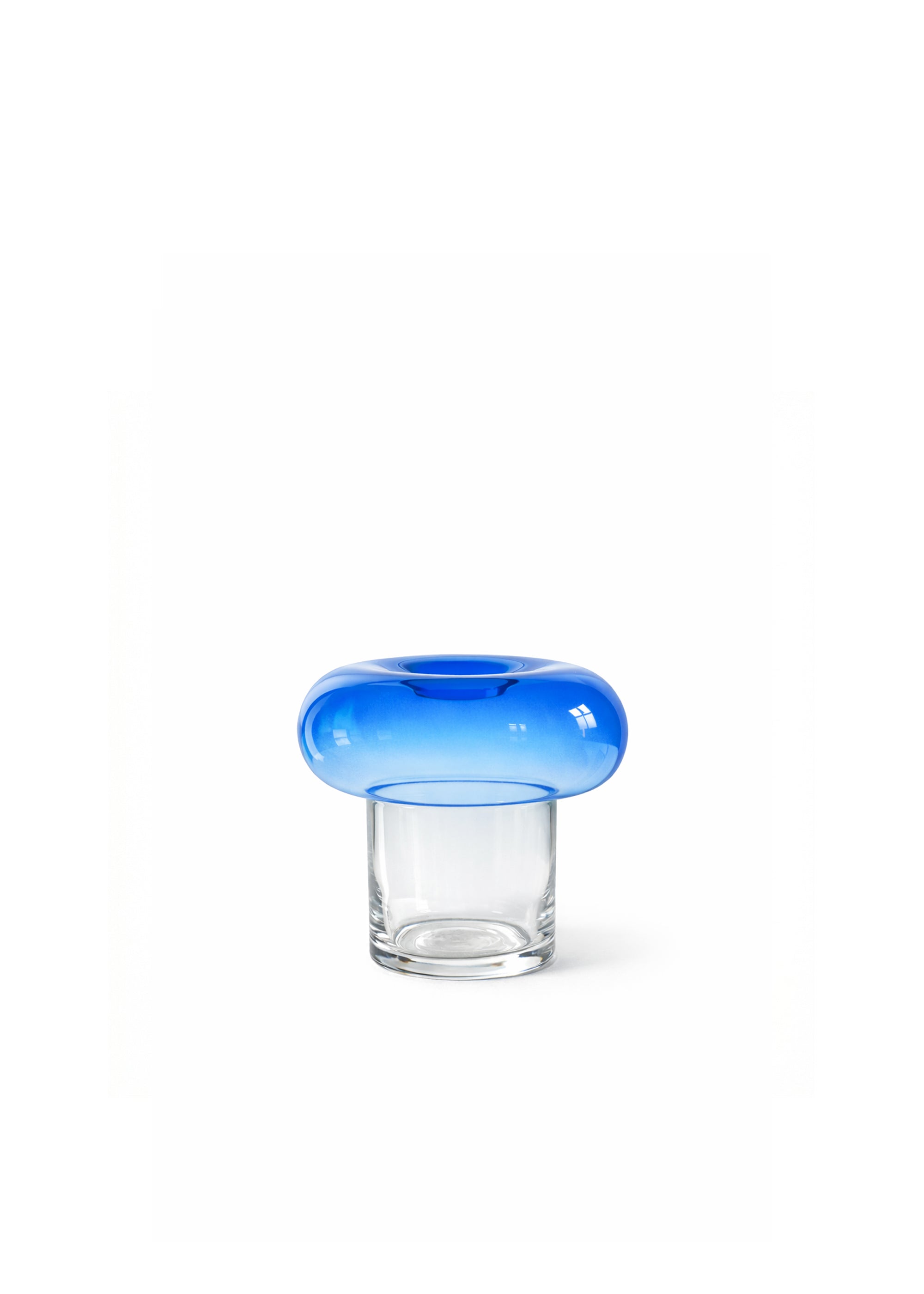 Niebieski szklany wazon z minimalistycznymi suszonymi kwiatami przed prześwitującymi, oświetlonymi słońcem zasłonami.