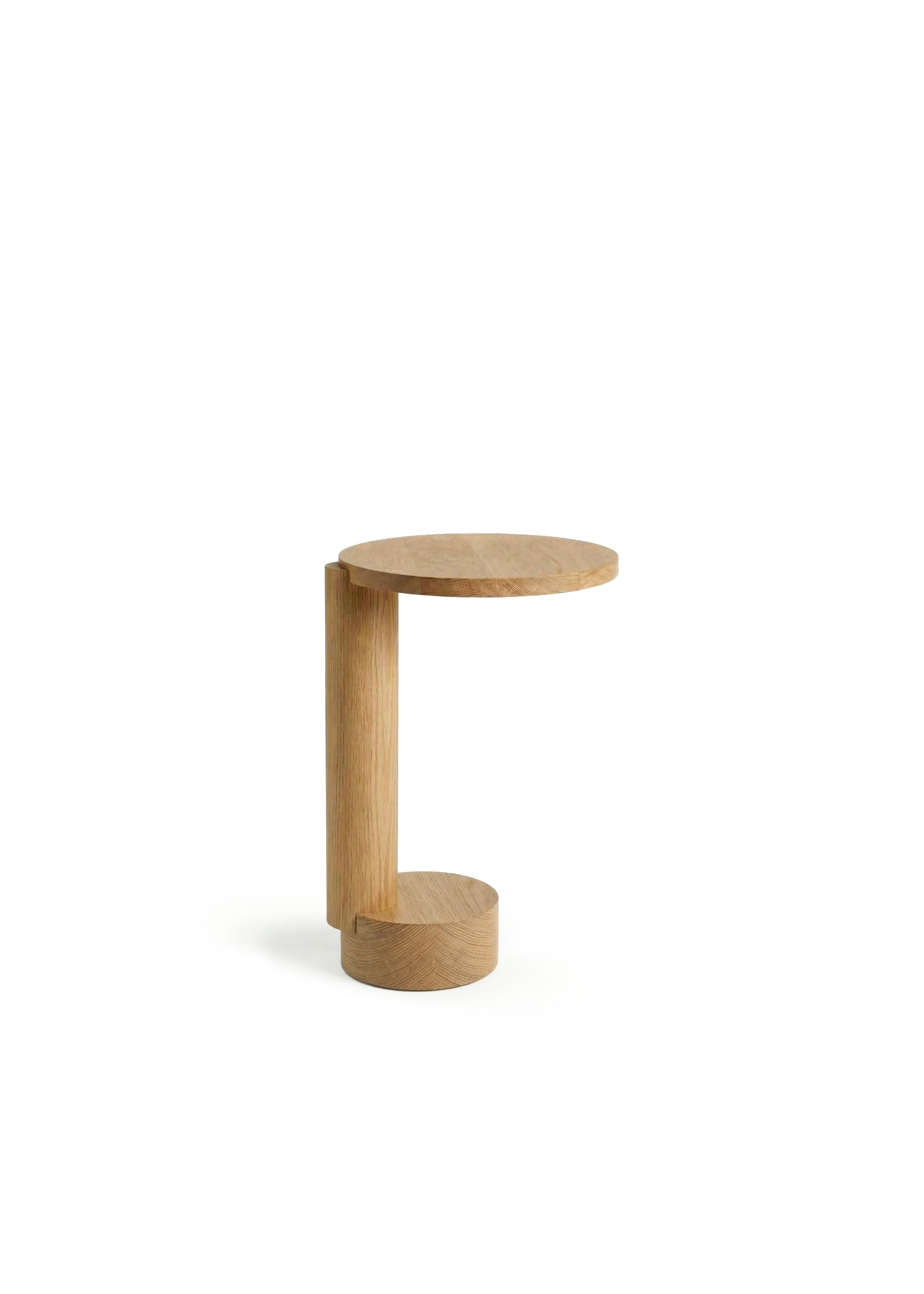 Jasny drewniany stolik z książkami i przedmiotem obok czarno-czerwonego krzesła.