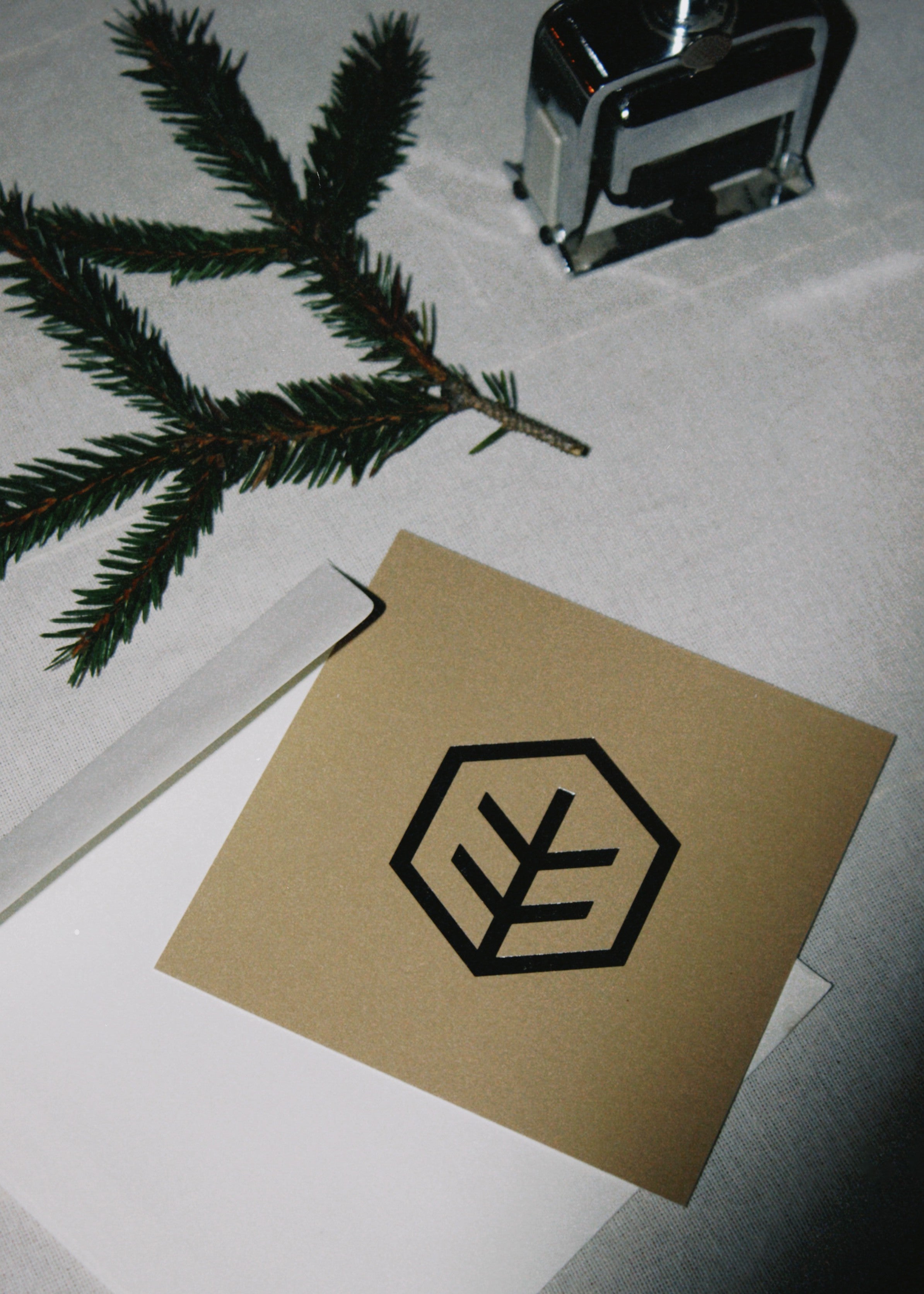 Zestaw drukowanych kart ułożonych na stole, z metalicznym wytłoczonym logo i minimalistycznym układem tekstu.